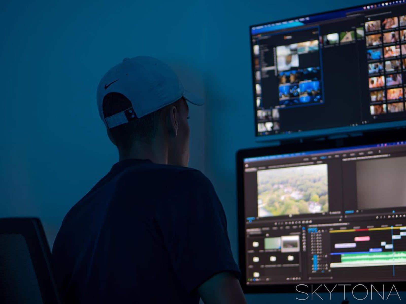 A Skytona editor working across two displays in a blue-lit edit room.